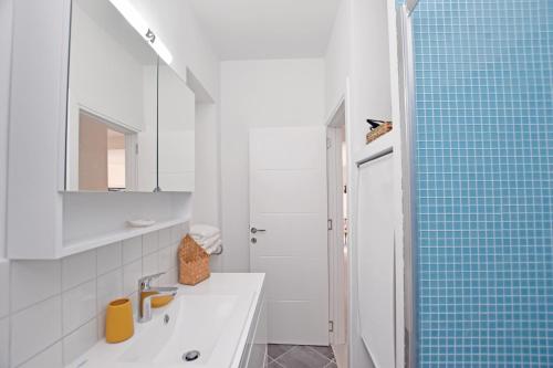 une salle de bain avec un lavabo et une douche avec du carrelage bleu dans l'établissement Blue Harbour Luxury Apartment, Herceg Novi , Old Town, à Herceg-Novi
