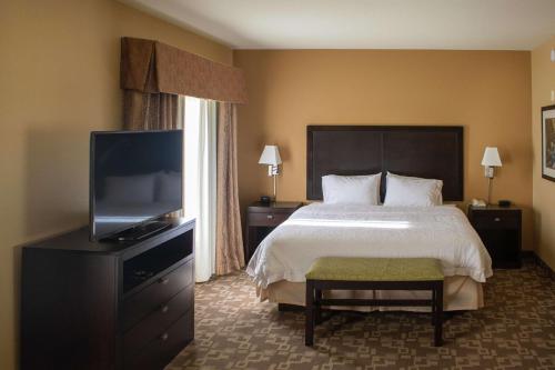 a hotel room with a bed and a flat screen tv at Hampton Inn & Suites-Knoxville/North I-75 in Knoxville