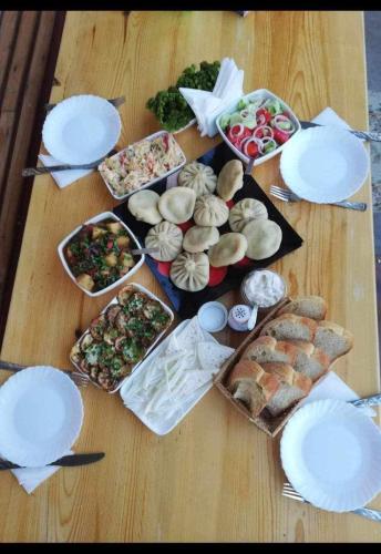 a table with plates and food on top of it at Guesthouse Mtkvari in Nak'alak'evi