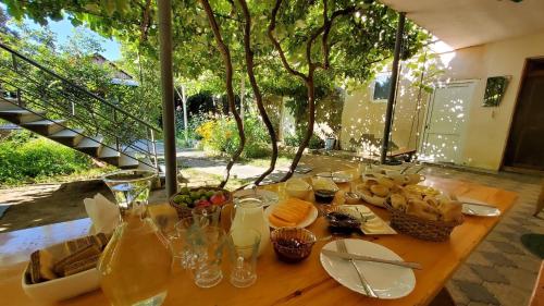 einem Holztisch mit Essen und Gläsern darauf in der Unterkunft Guesthouse Mtkvari in Nak'alak'evi