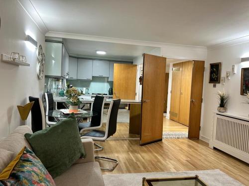 ロンドンにあるBayswater Apartmentsのリビングルーム(ソファ、テーブル付)、キッチンが備わります。