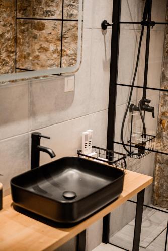 a bathroom with a black sink on a wooden table at Petra Elounda Suites - Adults Only in Elounda