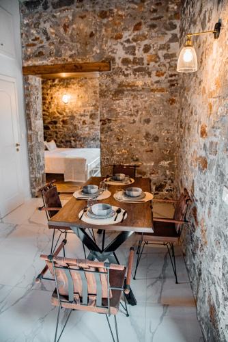 a dining room with a wooden table and chairs at Petra Elounda Suites - Adults Only in Elounda