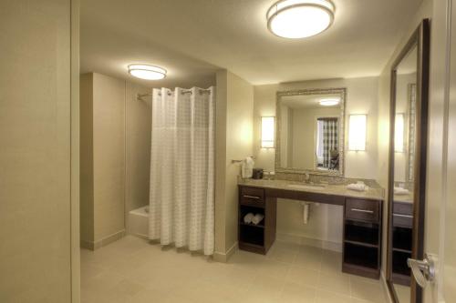 a bathroom with a shower curtain and a sink at Homewood Suites by Hilton Victoria in Victoria