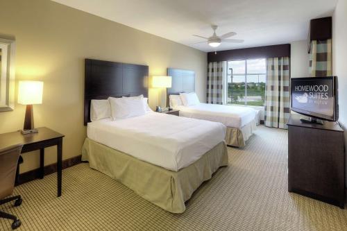 a hotel room with two beds and a flat screen tv at Homewood Suites by Hilton Victoria in Victoria