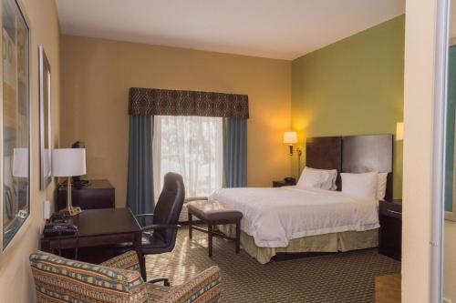 ein Hotelzimmer mit einem Bett und einem Schreibtisch in der Unterkunft Hampton Inn Dandridge in Dandridge