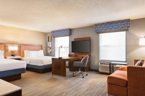 バルパライソにあるHampton Inn & Suites Valparaisoのベッド、デスク、コンピュータが備わるホテルルームです。