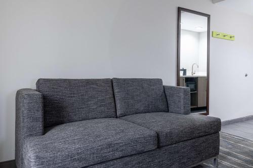 a gray couch in a living room with a mirror at Hampton Inn Knoxville-West At Cedar Bluff in Knoxville