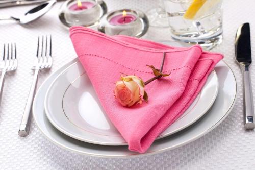 a pink napkin with a rose on top of a plate at Hilton Garden Inn Victorville in Victorville