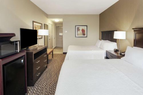 a hotel room with two beds and a flat screen tv at Hampton Inn Philadelphia/Voorhees in Voorhees