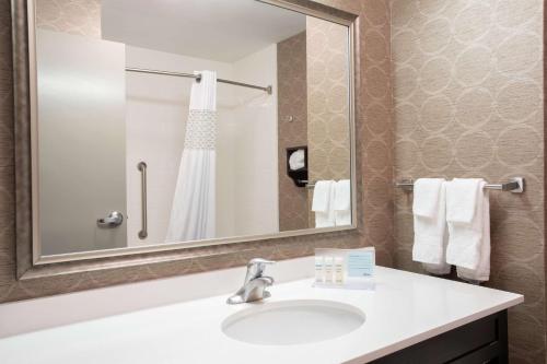 a bathroom with a sink and a mirror and towels at Hampton Inn Philadelphia/Voorhees in Voorhees