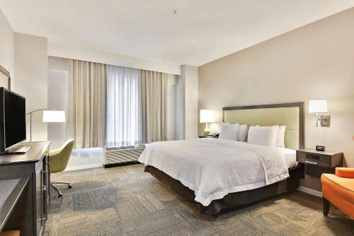 a hotel room with a bed and a flat screen tv at Hampton Inn Alexandria/Old Town in Alexandria