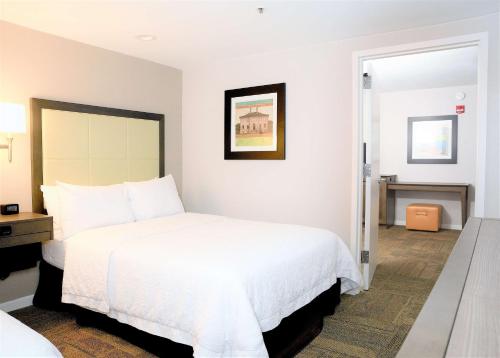 a bedroom with a large white bed and a doorway at Hampton Inn Alexandria/Old Town in Alexandria