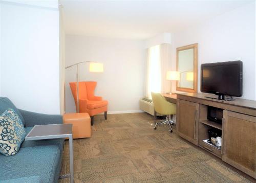 a living room with a couch and a tv and a chair at Hampton Inn Alexandria/Old Town in Alexandria