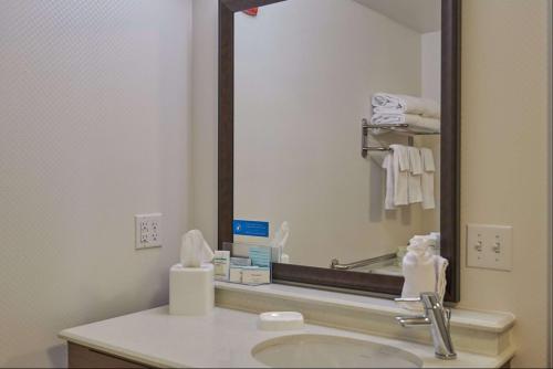 a bathroom with a sink and a large mirror at Hampton Inn Uniontown in Uniontown