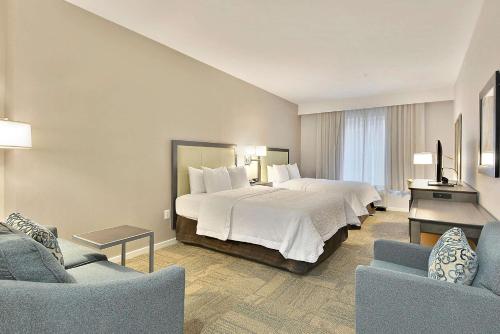 una camera d'albergo con un letto e due sedie di Hampton Inn Alexandria/Old Town a Alexandria