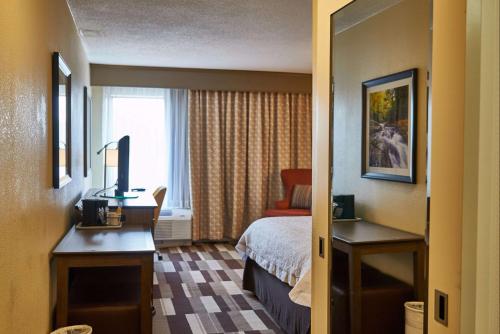 a hotel room with a bed and a window at Hampton Inn Uniontown in Uniontown