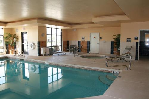 una gran piscina con sillas y mesas en un edificio en Hampton Inn Brighton, en Brighton