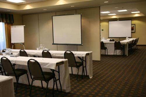 una sala de conferencias con mesas, sillas y pizarras en Hampton Inn Brighton, en Brighton