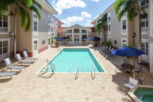 a swimming pool in a courtyard with chairs and umbrellas at Hampton Inn & Suites Venice Bayside South Sarasota in Venice