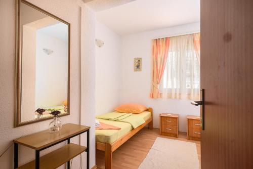 a small room with a bed and a mirror at Apartmani Šuki in Trogir