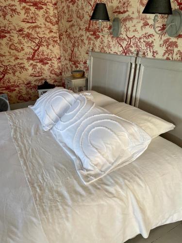 a white bed with two pillows on top of it at Belle Fontaine in Bourges