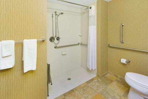 ein Bad mit einer Dusche, einem WC und Handtüchern in der Unterkunft Hampton Inn Waynesburg in Waynesburg