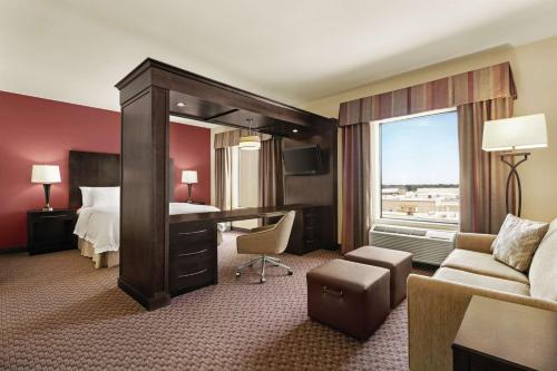 a hotel room with a bedroom with a bed and a desk at Hampton Inn & Suites Enid in Enid