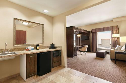 a bathroom with a sink and a living room at Hampton Inn & Suites Enid in Enid