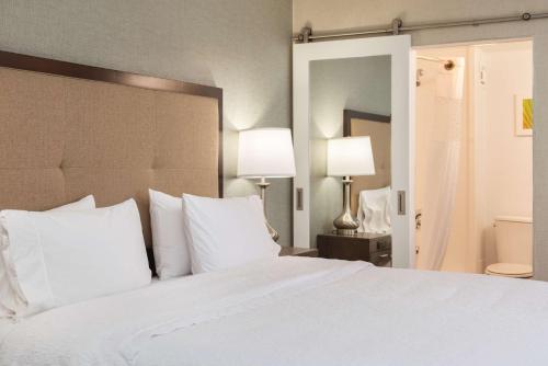 a bedroom with a large white bed with white pillows at Hampton Inn Los Angeles-West Covina in West Covina