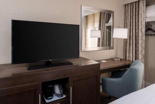 a hotel room with a flat screen tv on a desk at Hampton Inn Los Angeles-West Covina in West Covina