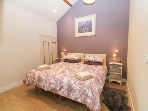 a bedroom with a bed with two pillows on it at Y Beudy in Caernarfon