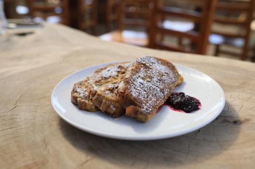 a white plate with french toast and berries on a table at Sarab Hotel in Ensenada