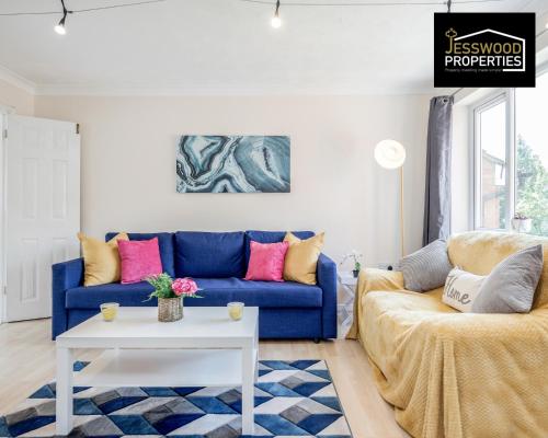 sala de estar con sofá azul y mesa blanca en Spacious 3BR, 3BA House by Jesswood Properties Short Lets For Contractors, With Free Parking Near M1 & Luton Airport, en Luton