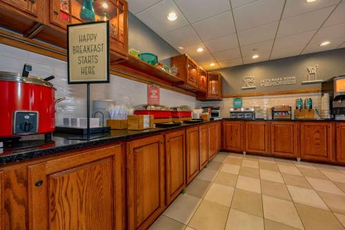 a restaurant kitchen with wooden cabinets and a sign at Hampton Inn Wheeling in Wheeling