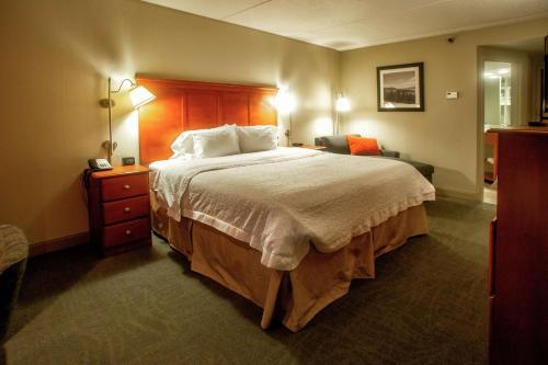 a hotel room with a large bed and a chair at Hampton Inn Wheeling in Wheeling