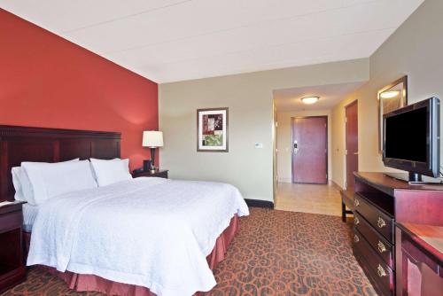 a hotel room with a bed and a flat screen tv at Hampton Inn Winfield Teays Valley in Teays Valley Estates