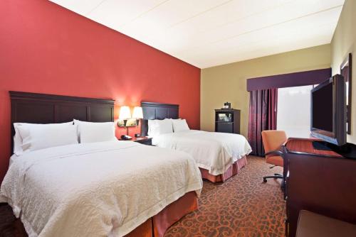 a hotel room with two beds and a flat screen tv at Hampton Inn Winfield Teays Valley in Teays Valley Estates