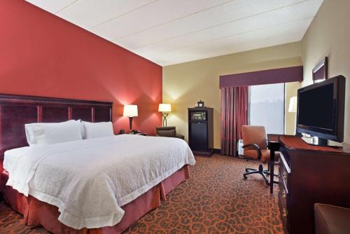 a hotel room with a bed and a flat screen tv at Hampton Inn Winfield Teays Valley in Teays Valley Estates