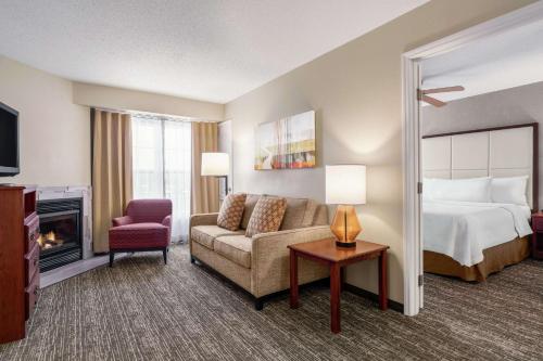 a hotel room with a bed and a couch and a chair at Homewood Suites by Hilton Providence-Warwick in Warwick