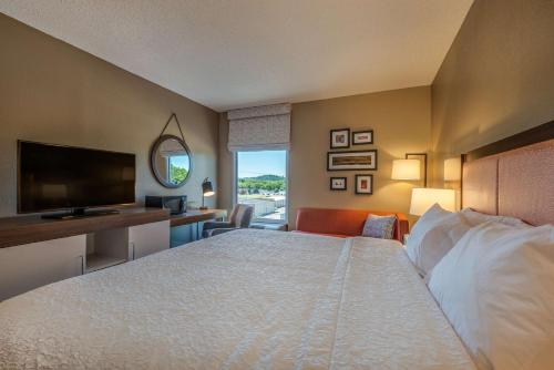 a hotel room with a bed and a flat screen tv at Hampton Inn Wilkesboro in Wilkesboro