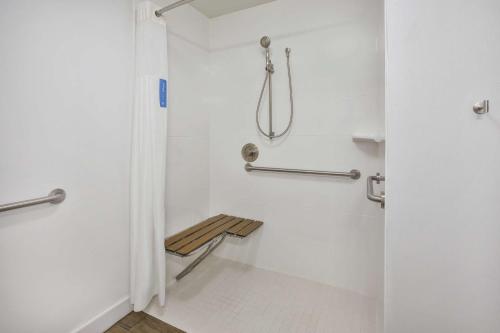 a shower stall with a bench in a bathroom at Hampton Inn White River Junction in White River Junction