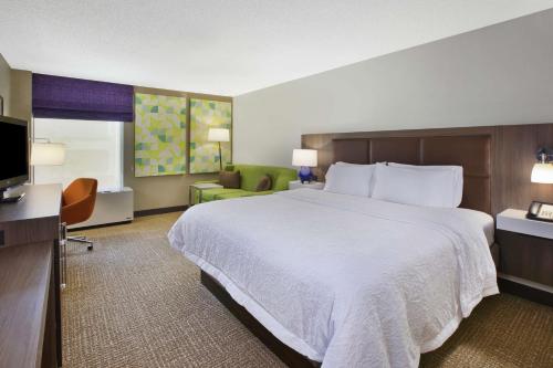 a hotel room with a large bed and a television at Hampton Inn White River Junction in White River Junction