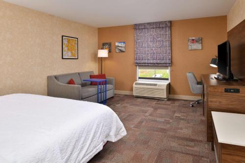 a hotel room with a bed and a desk and a television at Hampton Inn Wytheville in Wytheville