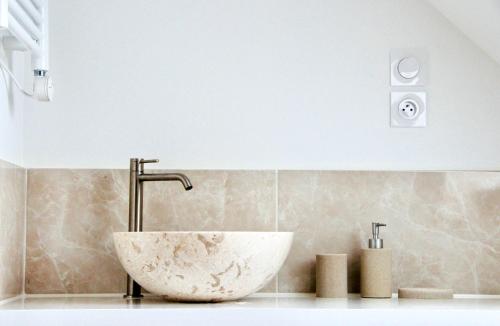 a bathroom with a sink with a large stone bowl at Maison Moz in Fontaines-en-Sologne