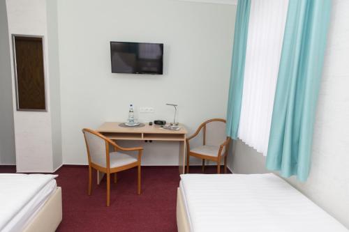 a room with a table and two chairs and a bed at Pension Der kleine Nachbar in Gotha