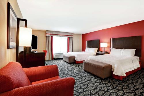 チリワックにあるHampton Inn by Hilton Chilliwackのベッド2台とソファが備わるホテルルームです。