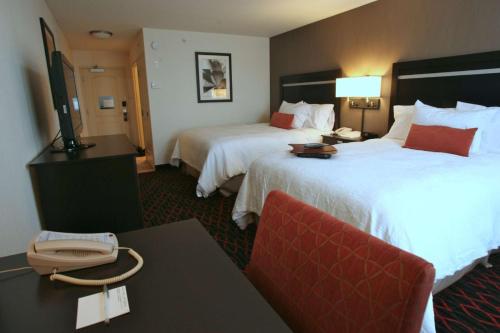 a hotel room with two beds and a phone on a table at Hampton Inn by Hilton Fort Saskatchewan in Fort Saskatchewan