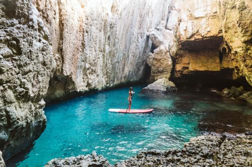 a person on a surfboard in the water in a cave at Dreamsea Mediterranean Camp in Benitachell