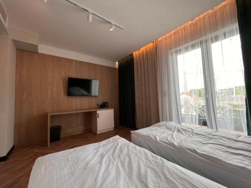a bedroom with a bed and a tv on a wall at Resto Inn - Smart apartamenty blisko Energylandii in Po”łwieś